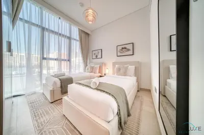 a bedroom with two beds and a large window at Ravishing 2BR at Azizi Riviera 30, Al Merkadh by Deluxe Holiday Homes in Dubai