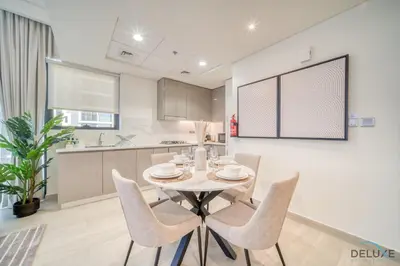 a kitchen and dining room with a table and chairs at Ravishing 2BR at Azizi Riviera 30, Al Merkadh by Deluxe Holiday Homes in Dubai