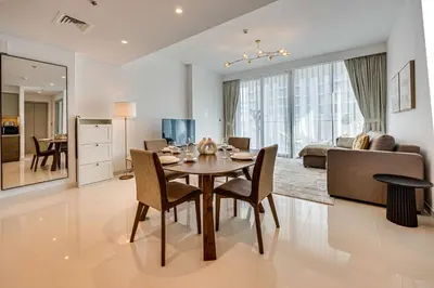 a dining room and living room with a table and chairs at Pleasant 1BD apartment with the beach access in Dubai