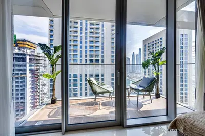 a room with windows with chairs and a view of a city at Pleasant 1BD apartment with the beach access in Dubai