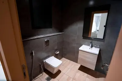 a bathroom with a toilet and a sink and a mirror at Stylish 1 Bedroom With Amazing View in Dubai