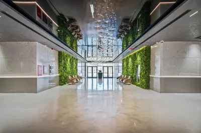 a hallway of a building with a green wall at Studion In Dubailand - Close Kitchen in Dubai