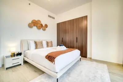 a bedroom with a large white bed with a wooden headboard at Luxury Madinat Living 2BR with Sea Views in Dubai