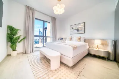 a bedroom with a white bed and a large window at Luxury Madinat Living 2BR with Sea Views in Dubai
