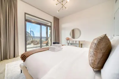 a bedroom with a bed and a large window at Luxury Madinat Living 2BR with Sea Views in Dubai