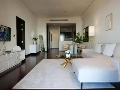 a living room with a white couch and a table at Elegant 1BR Full Palm View Apartment at 5 Star Resort in Dubai