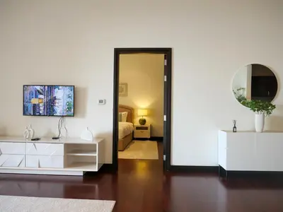 a living room with a white dresser and a mirror at Elegant 1BR Full Palm View Apartment at 5 Star Resort in Dubai