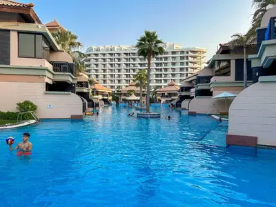 a boy in the swimming pool at a resort at Elegant 1BR Full Palm View Apartment at 5 Star Resort in Dubai