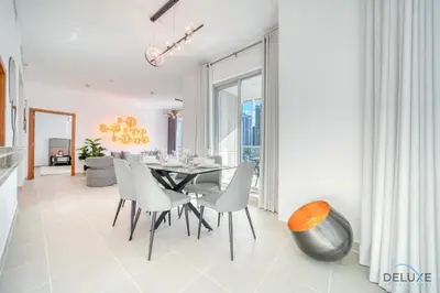 a dining room with a table and white chairs at Elegant 2BR at Beauport XI Dubai Marina by Deluxe Holiday Homes in Dubai