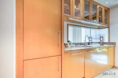 a kitchen with wooden cabinets and a sink at Elegant 2BR at Beauport XI Dubai Marina by Deluxe Holiday Homes in Dubai