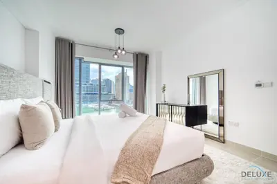 a bedroom with a white bed and a large window at Elegant 2BR at Beauport XI Dubai Marina by Deluxe Holiday Homes in Dubai