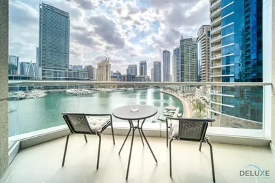 a balcony with a table and chairs and a view of the water at Elegant 2BR at Beauport XI Dubai Marina by Deluxe Holiday Homes in Dubai