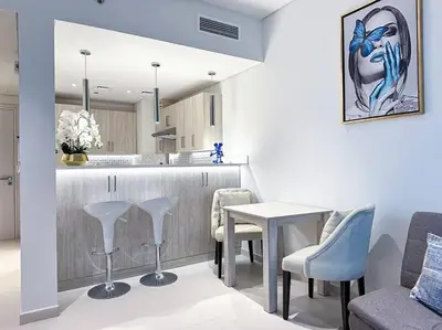 a kitchen and living room with a table and chairs at Seaside 1BR Getaway - Seven Palm in Dubai