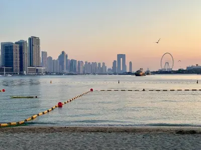 a long pier in the water with a city at Seaside 1BR Getaway - Seven Palm in Dubai