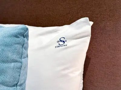 a white pillow with a saturday logo on it at Seaside 1BR Getaway - Seven Palm in Dubai