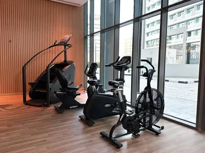 a gym with two exercise bikes in a room with windows at Seaside 1BR Getaway - Seven Palm in Dubai