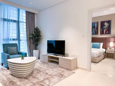 a large living room with a television and a couch at Seaside 1BR Getaway - Seven Palm in Dubai