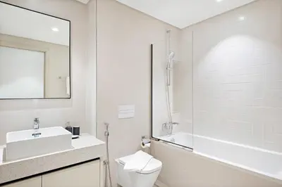 a bathroom with a toilet and a sink and a shower at Silkhaus Ultra Luxury 1BDR with Sea View in Dubai