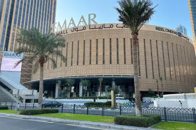 a large building with palm trees in front of it at Manzil - 1BR Apartment in Emaar Beachfront with Private Beach & Marina Access in Dubai