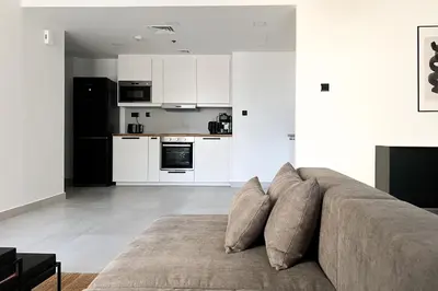 a living room with a couch and a kitchen at FavDubai presents 2BR apartment in The Heart of JBR and Dubai Marina 150 m to JBR Beach with famous Ain Dubai view the biggest ferris wheel in the world Swimming pool access, air-conditioned gym, free parking & Housekeeping in Dubai