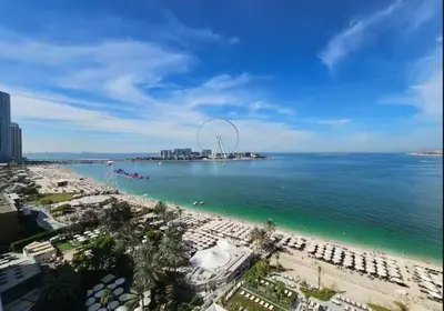 a beach with a ferris wheel in the water at Panoramic sea view from new 2BD in La Vie JBR in Dubai