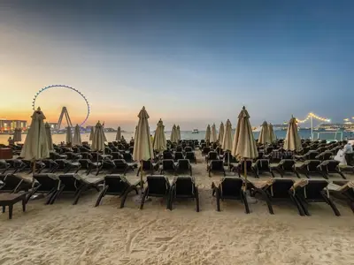 a group of chairs and umbrellas on a beach at Panoramic sea view from new 2BD in La Vie JBR in Dubai