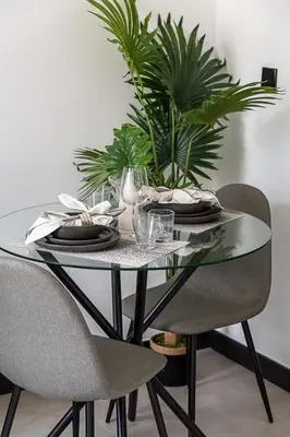 a glass table with two chairs and a plant on it at Frank Porter - 15 Northside in Dubai