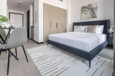 a bedroom with a large bed and a table and a chair at Frank Porter - 15 Northside in Dubai
