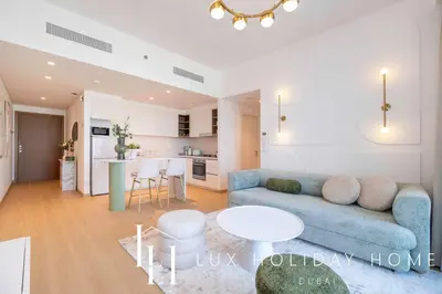 a living room with a blue couch and a kitchen at LUX The Downtown Zabeel View Suite 2 in Dubai