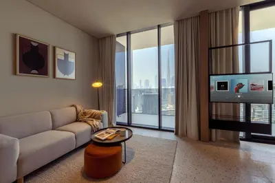 a living room with a couch and a large window at UPSIDE LIVING Downtown Business & Leisure in Dubai