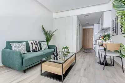a living room with a green couch and a table at Frank Porter - Ahad Residences in Dubai