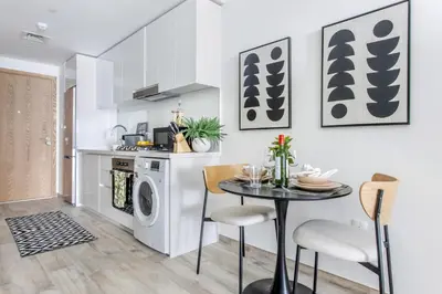 a kitchen with a table and a washing machine at Frank Porter - Ahad Residences in Dubai