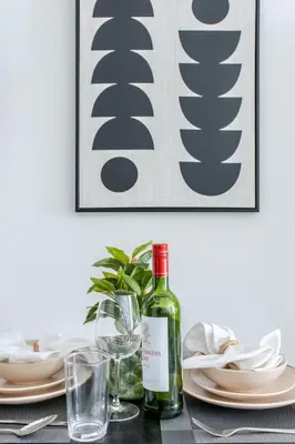 a table with a bottle of wine and glasses at Frank Porter - Ahad Residences in Dubai