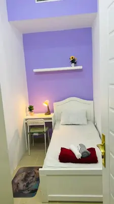 a bedroom with a white bed with a purple wall at Seperate Partition Room in Tecom / Barsha Heights in Dubai