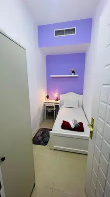 a bedroom with a white bed and a desk at Seperate Partition Room in Tecom / Barsha Heights in Dubai