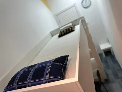 a bunk bed with a blue pillow and a clock at Cozy Loft Partition Room in Barsha Heights in Dubai