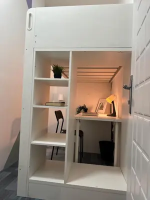a white bookcase in a room with a desk at Cozy Loft Partition Room in Barsha Heights in Dubai