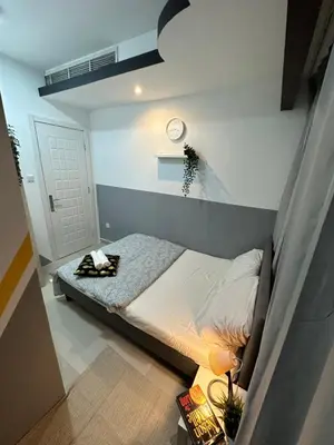 a bedroom with a bed and a clock on the wall at Double Partition Room in Al Barsha 1 Nearest to Metro in Dubai