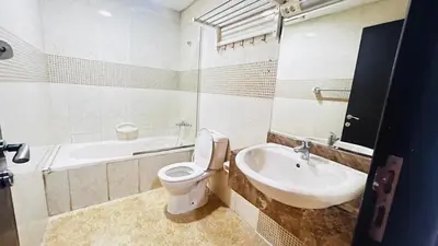 a white bathroom with a toilet and a sink at Double Partition Room in Al Barsha 1 Nearest to Metro in Dubai