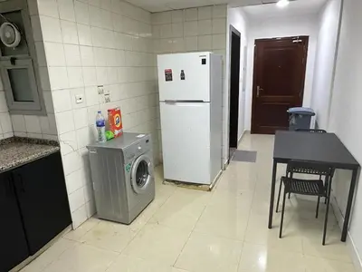 a kitchen with a washing machine and a refrigerator at Fancy Partition Room Near Mashreq Metro / SZ Road in Dubai