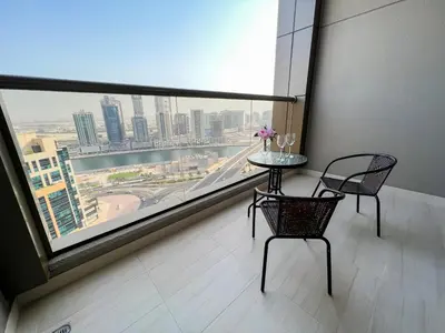 a table and chairs in a room with a large window at Modern Studio, Canal View, Elite Downtown, Dubai - 13AB06 in Dubai