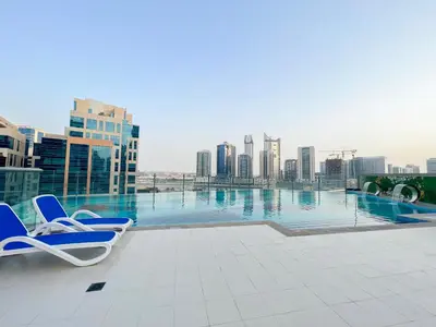 two chairs on a rooftop with a view of a city at Modern Studio, Canal View, Elite Downtown, Dubai - 13AB06 in Dubai