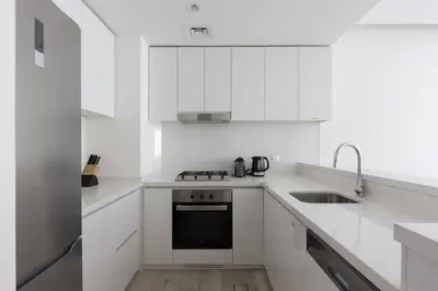 a white kitchen with a sink and a stove at Ahad Residence Walking Distance to Dubai Mall in Dubai