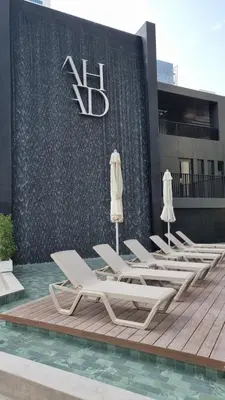 a row of lounge chairs and umbrellas in front of a building at Ahad Residence Walking Distance to Dubai Mall in Dubai