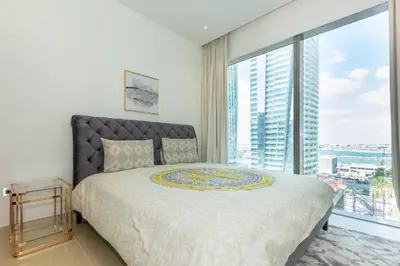 a bedroom with a large bed and a large window at HomesGetaway- 2BRLuxury Apartment at Marina Gate 2 in Dubai