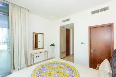 a white bedroom with a bed and a mirror at HomesGetaway- 2BRLuxury Apartment at Marina Gate 2 in Dubai