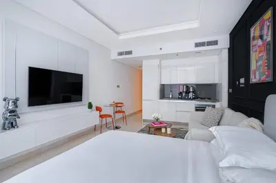 a living room with a couch and a tv on a wall at Luxurious Flat 3 Min to Burj Khalifa Sleeps 3 in Dubai