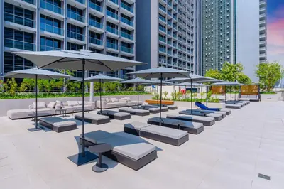 a group of tables and umbrellas in a courtyard at Luxurious Flat 3 Min to Burj Khalifa Sleeps 3 in Dubai