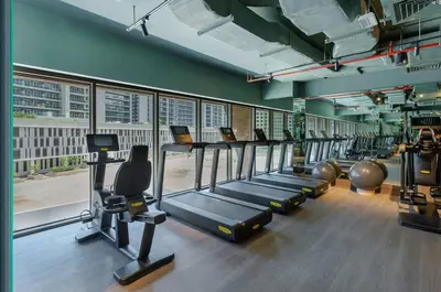 a gym with a row of treadms and cardio machines at Luxurious Flat 3 Min to Burj Khalifa Sleeps 3 in Dubai
