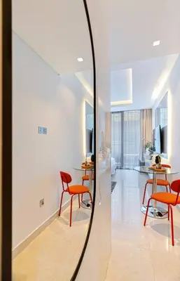 a mirror in a room with chairs and tables at Luxurious Flat 3 Min to Burj Khalifa Sleeps 3 in Dubai